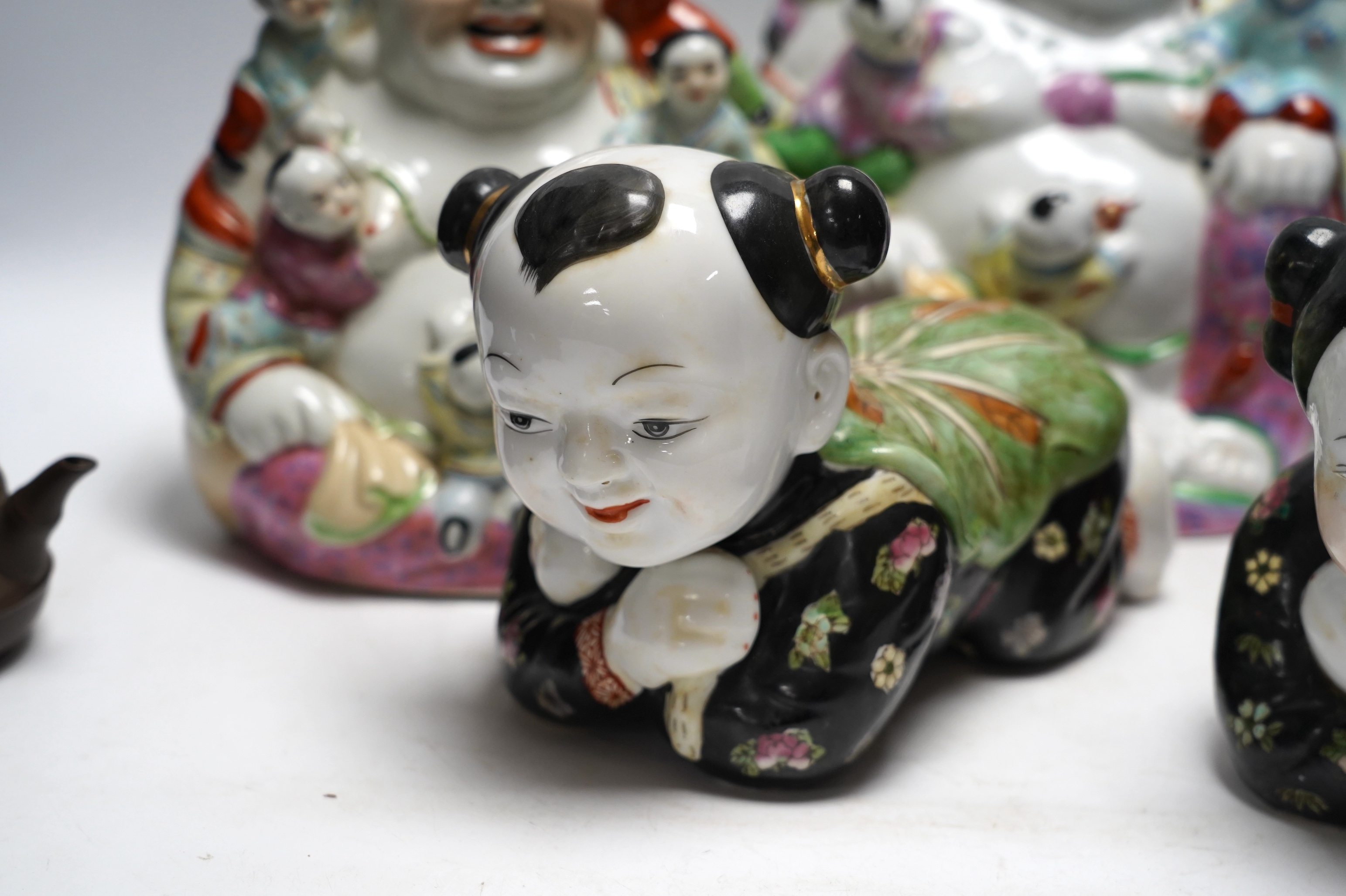 Two figural Chinese pillows, two famille rose Budai groups and three yixing teapots, tallest 25cm